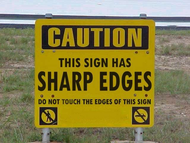 a photo of a sign that says caution this sign has sharp edges